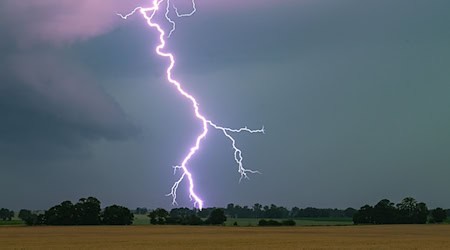 Ein Blitz leuchtet über einer Landschaft auf. / Foto: Patrick Pleul/dpa