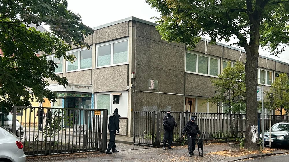 Vermummte Polizisten stehen an einem Gebäude, in dem sich das Islamische Zentrum Berlin befindet. / Foto: Sven Käuler/TNN/dpa