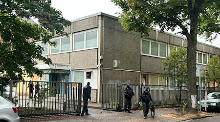 Vermummte Polizisten stehen an einem Gebäude, in dem sich das Islamische Zentrum Berlin befindet. / Foto: Sven Käuler/TNN/dpa