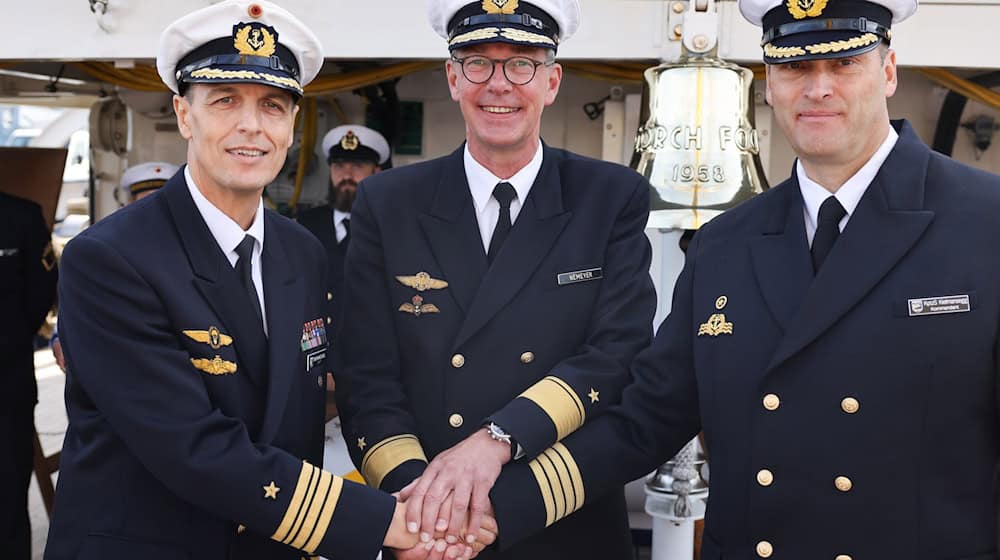 Fregattenkapitän Elmar Bornkessel (l) wird von Flotillenadmiral Jens Nemeyer (M) das Kommando über die «Gorch Fock» übertragen. / Foto: Christian Charisius/dpa