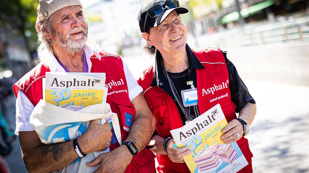 Scorpions-Sänger Klaus Meine (rechts) unterstützt Uwe, einen Verkäufer des Straßenmagazins «Asphalt». / Foto: Moritz Frankenberg/dpa