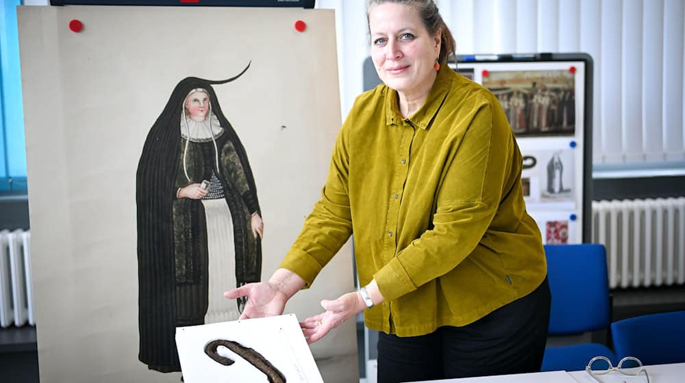 Annette Schieck, Leiterin des Deutschen Textilmuseums in Krefeld, zeigt bei der Präsentation bedeutender Textilfunde aus dem 16. und 17. Jahrhundert ein Horn aus Stoff. Es ist eine Besonderheit in Bremen. / Foto: Sina Schuldt/dpa