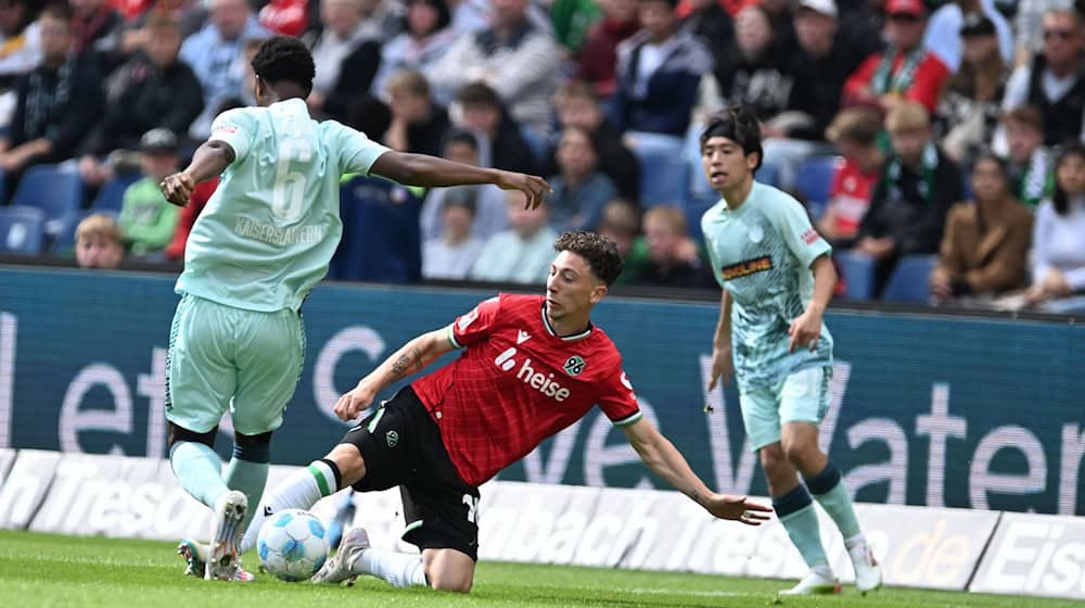 Voller Einsatz: Hannovers Jannik Rochelt (M) im Zweikampf mit Kaiserslauterns Almamy Toure (l) / Foto: Carmen Jaspersen/dpa