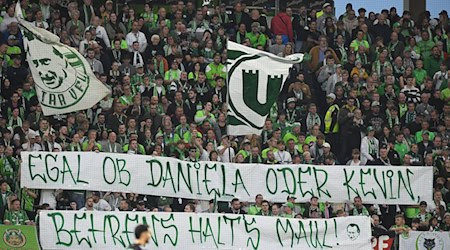 Wolfsburger Fans protestieren gegen Spieler Kevin Behrens und Niedersachsens Innenministerin Daniela Behrens. / Foto: Swen Pförtner/dpa