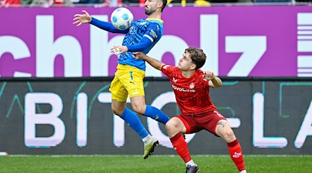 Braunschweigs Fabio Kaufmann (l) und Kaiserslauterns Florian Kleinhansl kämpfen um den Ball. / Foto: Uwe Anspach/dpa