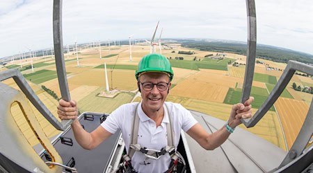 Der CDU-Bundesvorsitzende Friedrich Merz steigt auf das Maschinenhaus einer Windkraftanlage. (Archivbild) / Foto: Friso Gentsch/dpa