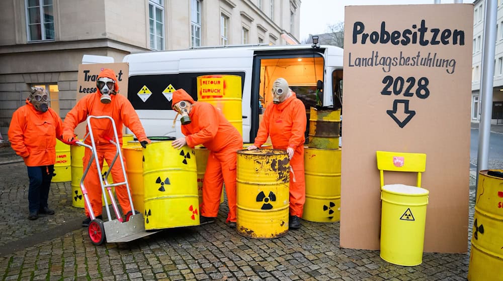 Demonstranten der Bürgerinitiative Strahlenschutz Leese stehen mit künstlichen Atommüllfässern vor dem niedersächsischen Landtag. / Foto: Julian Stratenschulte/dpa