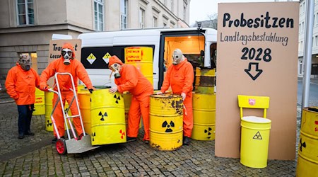 Demonstranten der Bürgerinitiative Strahlenschutz Leese stehen mit künstlichen Atommüllfässern vor dem niedersächsischen Landtag. / Foto: Julian Stratenschulte/dpa