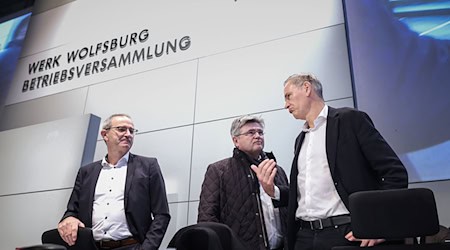 Konzernchef Oliver Blume (r.) berät sich vor seiner Rede mit  VW-Verhandlungsführer Arne Meiswinke (Mitte). / Foto: Ronny Hartmann/POOL/dpa