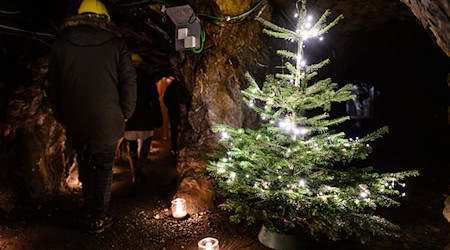 Besucher gehen über den Weihnachtsmarkt unter Tage. / Foto: Swen Pförtner/dpa