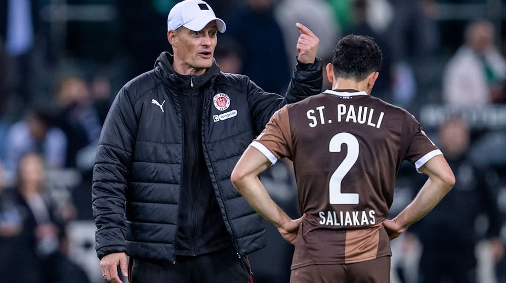 St. Paulis Manolis Saliakas (r) im Gespräch mit Trainer Alexander Blessin. Im Testspiel bei Eintracht Braunschweig erzielt der Abwehrspieler ein Eigentor.  / Foto: David Inderlied/dpa