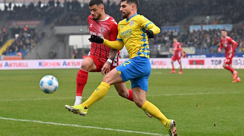 Mit vollem Einsatz: Braunschweigs Fabio Di Michele Sanchez und Kölns Jusuf Gazibegović im Zweikampf um den Ball. / Foto: Swen Pförtner/dpa