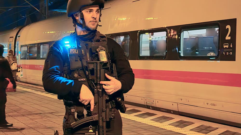 Ein Polizist steht auf dem Bahnsteig vor dem ICE in Elze. / Foto: Carsten Neff/News & Art/dpa