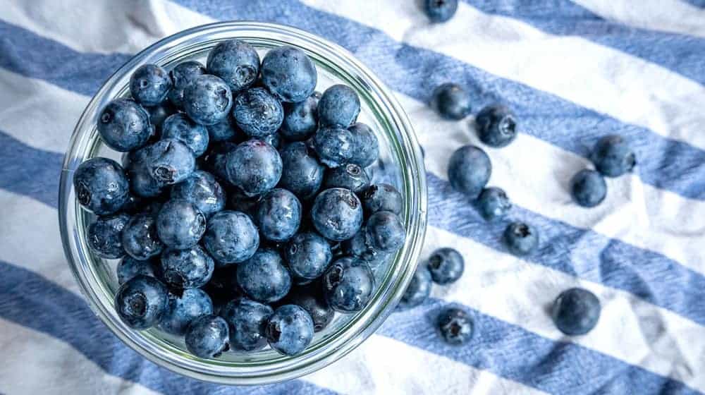 Beeren statt Chips oder Nüsschen: Heidelbeeren, auch Blaubeeren genannt, liegen auf einem Esstisch und werden gern gesnackt. / Foto: Sina Schuldt/dpa
