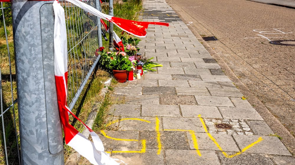 An dem Tatort in einer Wohngegend in Varel liegen inzwischen Blumen und Kerzen. / Foto: Sina Schuldt/dpa