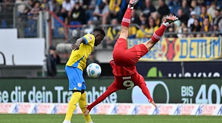 Düsseldorfs Giovanni Haag (r) mit einer akrobatischen Einlage gegen Braunschweig Richmond Tachie. / Foto: Swen Pförtner/dpa