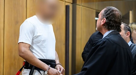 Der Angeklagte wurde mit Hand- und Fußfesseln in den Gerichtssaal gebracht.  / Foto: Julian Stratenschulte/dpa