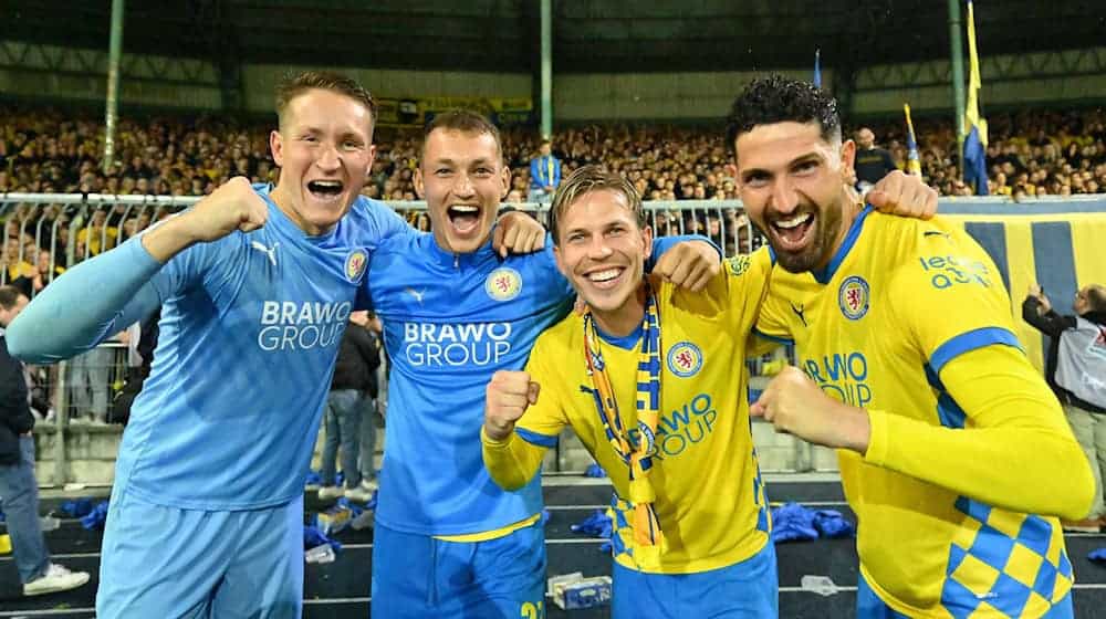 Kritisiert den eigenen Verein: Braunschweigs Sven Köhler (2. v.l.), zusammen mit Ron-Thorben Hoffmann, Lino Tempelmann und Fabio Kaufmann nach der erfolgreichen Relegation gegen den 1. FC Saarbrücken. / Foto: Swen Pförtner/dpa