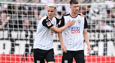 Bastian Allgeier versucht Tom Gaal nach seinem Eigentor aufzumuntern. / Foto: Harry Langer/dpa