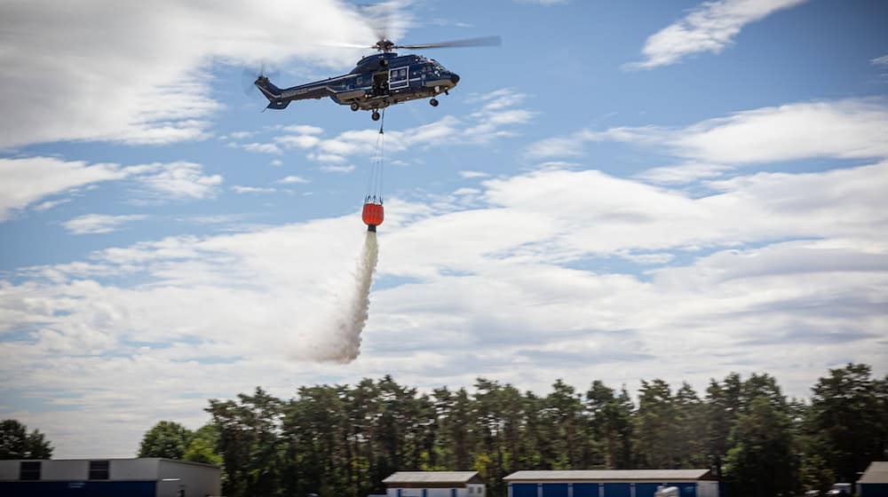 Ein Hubschrauber der Bundespolizei wirft bei einer Waldbrandübung Wasser aus einem Löschwasserbehälter ab. / Foto: Moritz Frankenberg/dpa