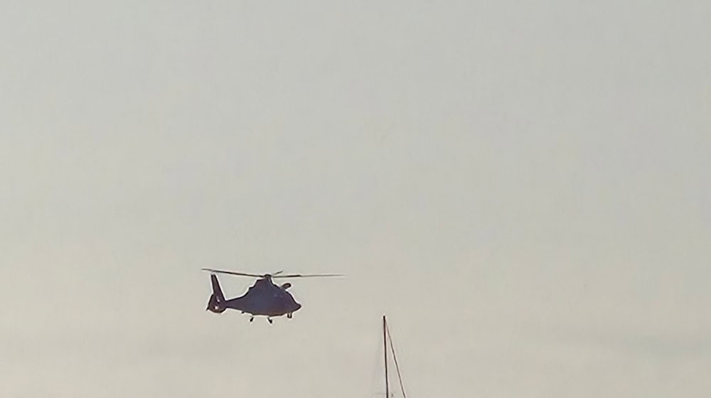 Vor der Insel Spiekeroog bringt ein Hubschrauber einen Sanitäter an Bord eines Segelboots. / Foto: DGzRS - Die Seenotretter/dpa