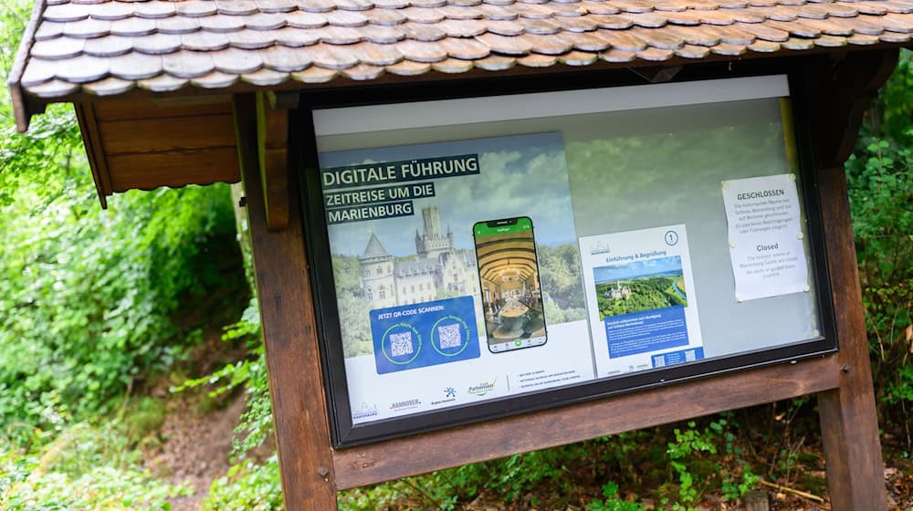 Ein Schild weist auf eine digitale Führung per Smartphone am Schloss Marienburg in der Region Hannover hin. / Foto: Julian Stratenschulte/dpa