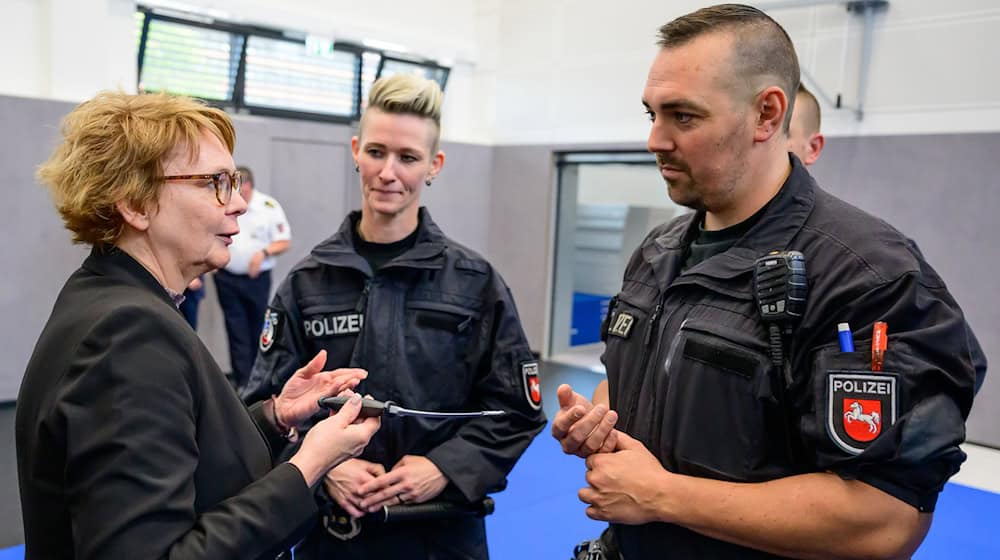 Daniela Behrens (links, SPD), Innenministerin Niedersachsen, spricht mit Polizisten kurz nach einem Einsatztraining.  / Foto: Philipp Schulze/dpa