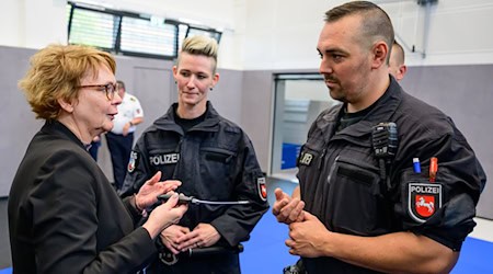 Daniela Behrens (links, SPD), Innenministerin Niedersachsen, spricht mit Polizisten kurz nach einem Einsatztraining.  / Foto: Philipp Schulze/dpa
