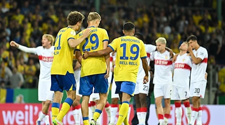 Braunschweiger Spieler trösten ihren Teamkollegen Lukas Frenkert nach seinem verschossenen Elfmeter gegen den VfB Stuttgart.  / Foto: Swen Pförtner/dpa