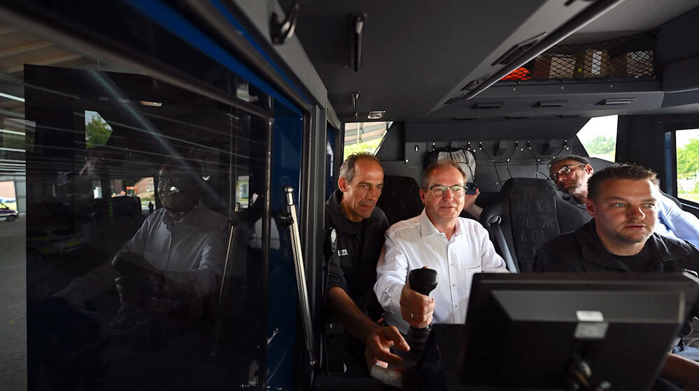 Bundesinnenminister Alexander Dobrindt lässt sich die Funktionsweise eines Wasserwerfers erklären und steigt dafür auch selbst in das Fahrzeug. / Foto: Hendrik Schmidt/dpa