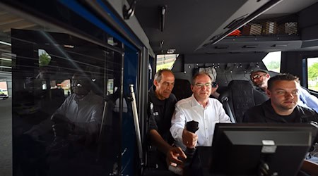 Bundesinnenminister Alexander Dobrindt lässt sich die Funktionsweise eines Wasserwerfers erklären und steigt dafür auch selbst in das Fahrzeug. / Foto: Hendrik Schmidt/dpa