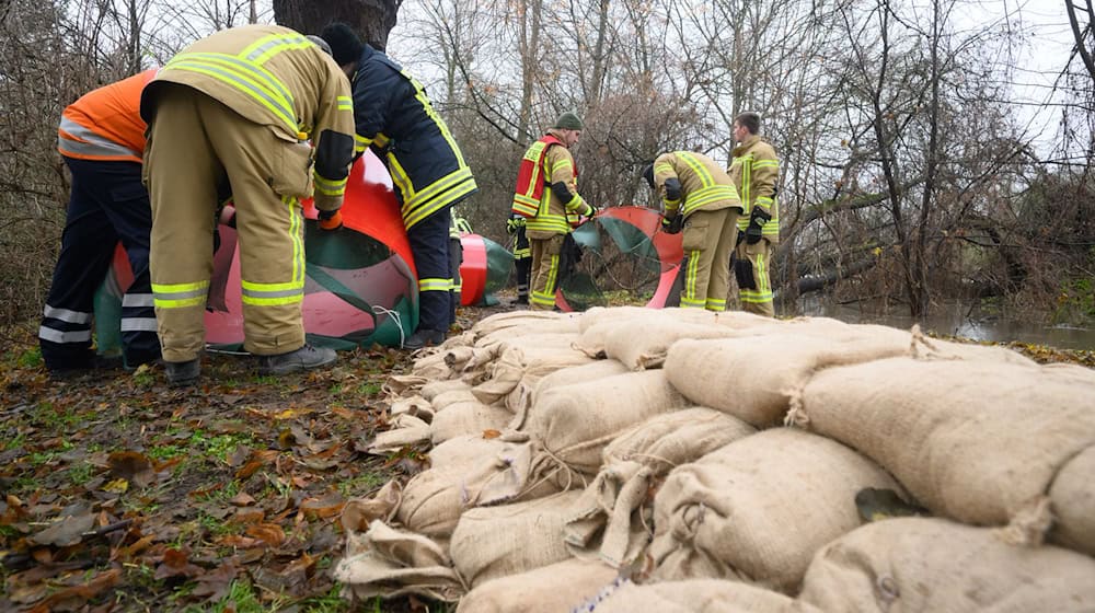 Mit Sandsäcken schützten Einsatzkräfte an Heiligabend 2023 bedrohte Häuser vor dem steigenden Wasser. (Archivbild) / Foto: Julian Stratenschulte/dpa