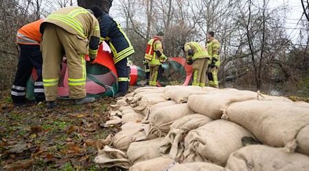 Mit Sandsäcken schützten Einsatzkräfte an Heiligabend 2023 bedrohte Häuser vor dem steigenden Wasser. (Archivbild) / Foto: Julian Stratenschulte/dpa