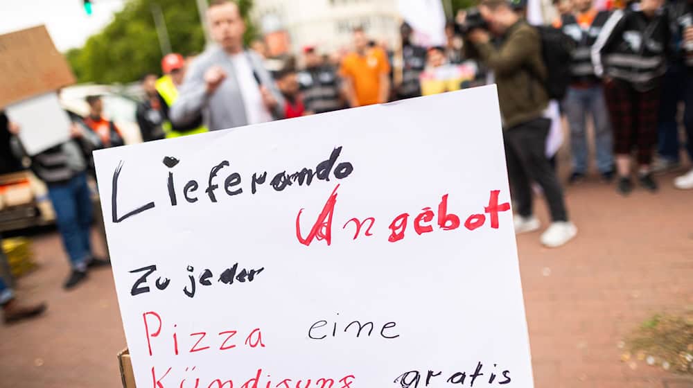 Beschäftigte des Essenslieferdienstes Lieferando nehmen an einer Kundgebung auf dem Weißekreuzplatz teil. Lieferando plant, den Lieferbetrieb in einigen Städten einzustellen. / Foto: Moritz Frankenberg/dpa