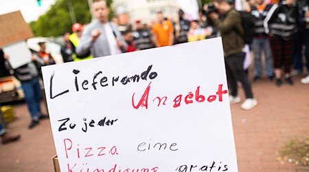 Beschäftigte des Essenslieferdienstes Lieferando nehmen an einer Kundgebung auf dem Weißekreuzplatz teil. Lieferando plant, den Lieferbetrieb in einigen Städten einzustellen. / Foto: Moritz Frankenberg/dpa