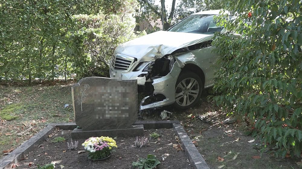 Infolge eines Ausweichmanövers durchbrach das Auto die Hecke eines Friedhofs.  / Foto: -/Nord-West-Media TV/dpa