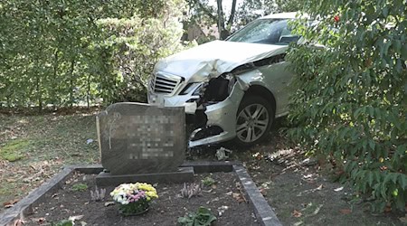 Infolge eines Ausweichmanövers durchbrach das Auto die Hecke eines Friedhofs.  / Foto: -/Nord-West-Media TV/dpa