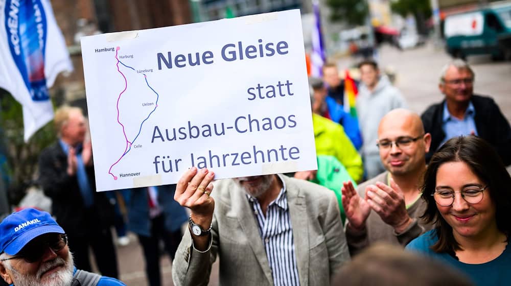 Menschen demonstrieren für den Neubau der Bahnstrecke Hamburg-Hannover.  / Foto: Julian Stratenschulte/dpa