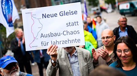 Menschen demonstrieren für den Neubau der Bahnstrecke Hamburg-Hannover.  / Foto: Julian Stratenschulte/dpa