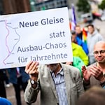 Menschen demonstrieren für den Neubau der Bahnstrecke Hamburg-Hannover.  / Foto: Julian Stratenschulte/dpa