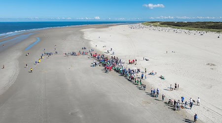 Hunderte Ostfriesen haben sich am Badestrand von Spiekeroog im Klootschießen gemessen - eigentlich wird bei dem Friesensport sonst auf Feldern oder Wegen mit Holzkugeln geworfen.  / Foto: Kai Kröger/Gemeinde Spiekeroog/dpa