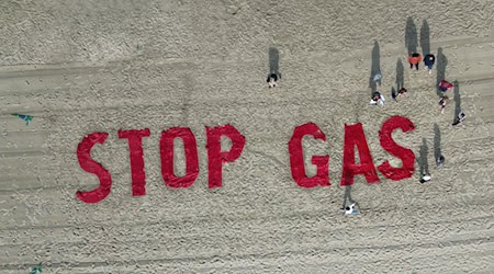 Bei einem Protest auf Borkum im Juli hatten Klimaschutzaktivisten von Fridays for Future ihre Forderung in den Sand geschrieben. (Archivbild) / Foto: Lars Penning/dpa