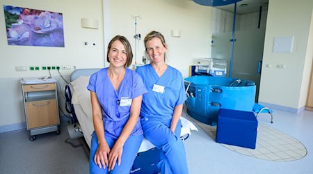 Die Hebammen Antje Kuhrau (l) und Franziska Pfeil sitzen in einem Kreißsaal des Klinikums Lüneburg. Seit diesem Monat können Frauen in Begleitung von zwei Hebammen entbinden. / Foto: Philipp Schulze/dpa