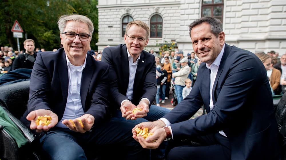 Oberbürgermeister Jürgen Krogmann (SPD) sowie die Ministerpräsidenten Daniel Günther (CDU) und Olaf Lies (SPD) sitzen in der Kutsche des Festumzugs zum diesjährigen Kramermarkt in Oldenburg. / Foto: Hauke-Christian Dittrich/dpa