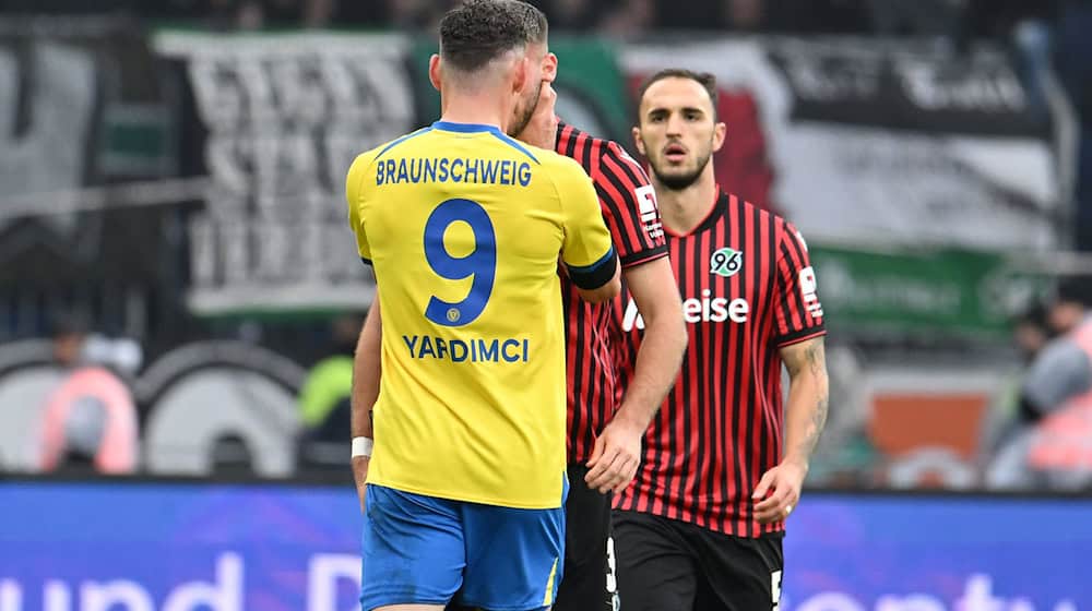 Erencan Yardimci von Eintracht Braunschweig fasst seinem Gegenspieler Boris Tomiak beim Derby gegen Hannover 96 mit beiden Händen an den Hals. / Foto: Swen Pförtner/dpa
