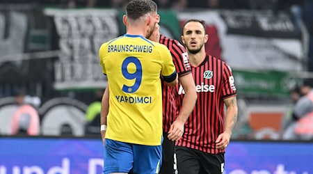 Erencan Yardimci von Eintracht Braunschweig fasst seinem Gegenspieler Boris Tomiak beim Derby gegen Hannover 96 mit beiden Händen an den Hals. / Foto: Swen Pförtner/dpa Erencan Yardimci von Eintracht Braunschweig fasst seinem Gegenspieler Boris Tomiak beim Derby gegen Hannover 96 mit beiden Händen an den Hals. / Foto: Swen Pförtner/dpa