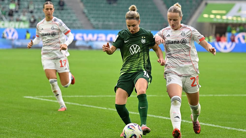 Wolfsburgs Svenja Huth (M) im Zweikampf mit Franziska Kett vom FC Bayern München. / Foto: Swen Pförtner/dpa