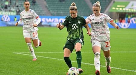 Wolfsburgs Svenja Huth (M) im Zweikampf mit Franziska Kett vom FC Bayern München. / Foto: Swen Pförtner/dpa
