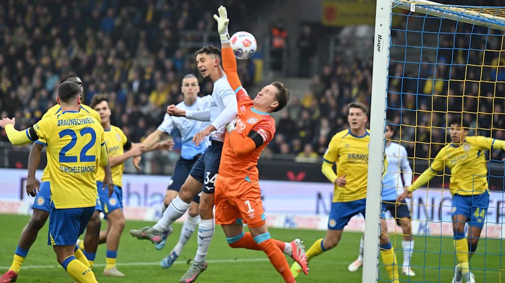 Das Tor zum 0:1: Bochums Cajetan Lenz ist eher am Ball als Braunschweigs Torwart Ron-Thorben Hoffmann. / Foto: Swen Pförtner/dpa