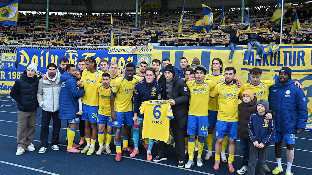 Jubel mit Flick-Trikot: Die Spieler von Eintracht Braunschweig grüßen nach dem 2:0-Sieg gegen Kaiserslautern ihren verletzten Mitspieler. / Foto: Swen Pförtner/dpa
